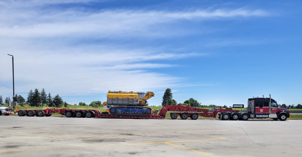 Scott-Woods heavy haul fleet transporting oversized crawler crane equipment using specialized multi-axle trailer configurations.