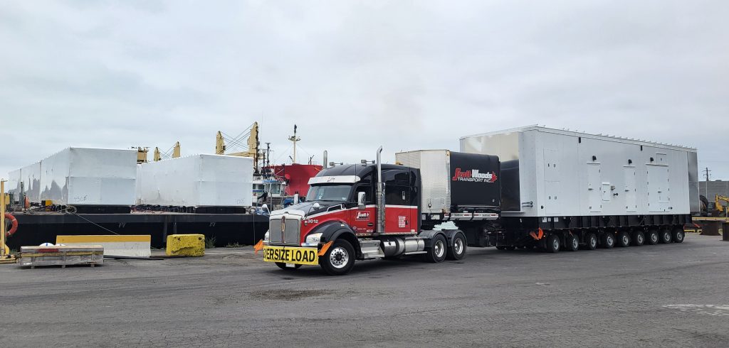 Specialized transportation equipment supporting an oversized industrial freight project at a port facility.
