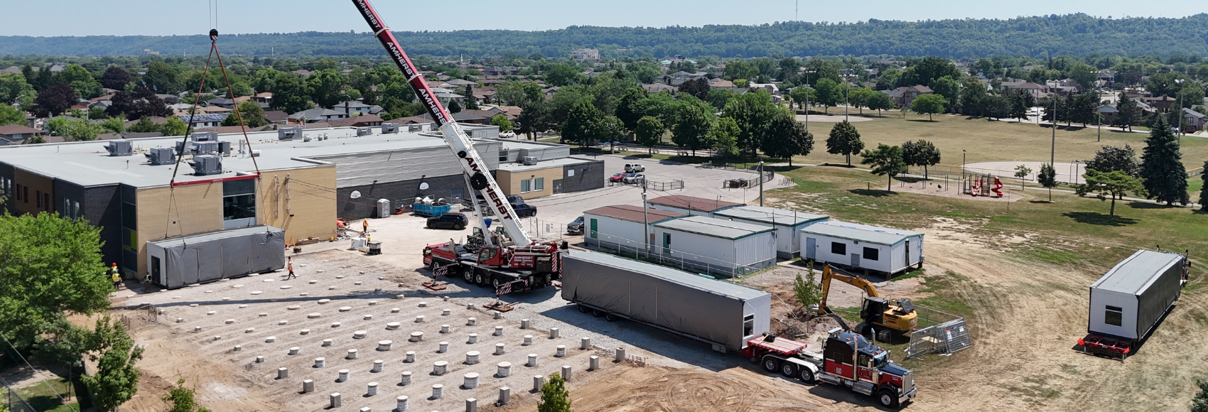 Installing portable classrooms in summer weather with heavy haul transportation